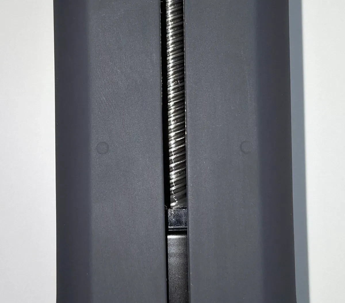 Close-up of the Handy 2 body: the drive screw seen through the slot, and a round dimple on each side